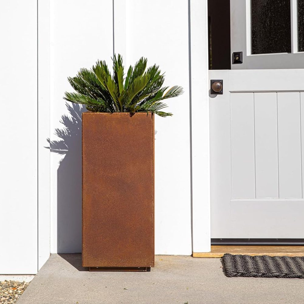 A rectangular corten steel planter box with plants